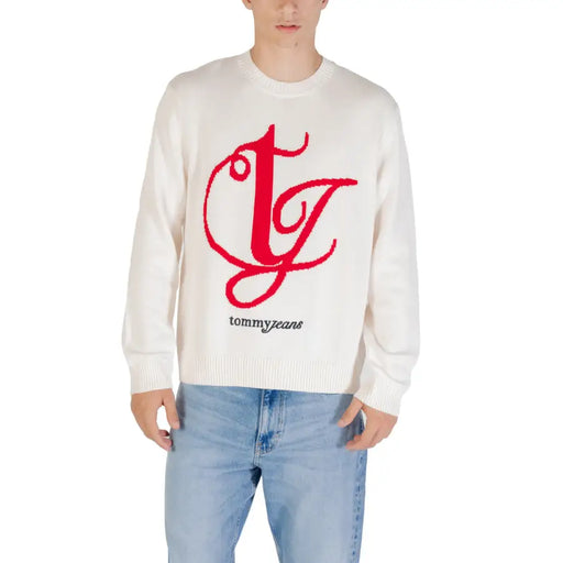 White sweater with red bold cursive logo and tommy brand name embroidered below on a cotton fabric front side