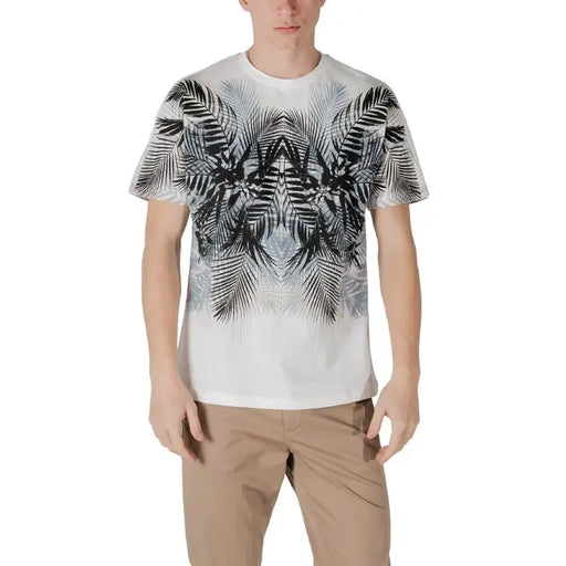 Man wearing a white T-shirt with black and gray palm leaf pattern and khaki pants