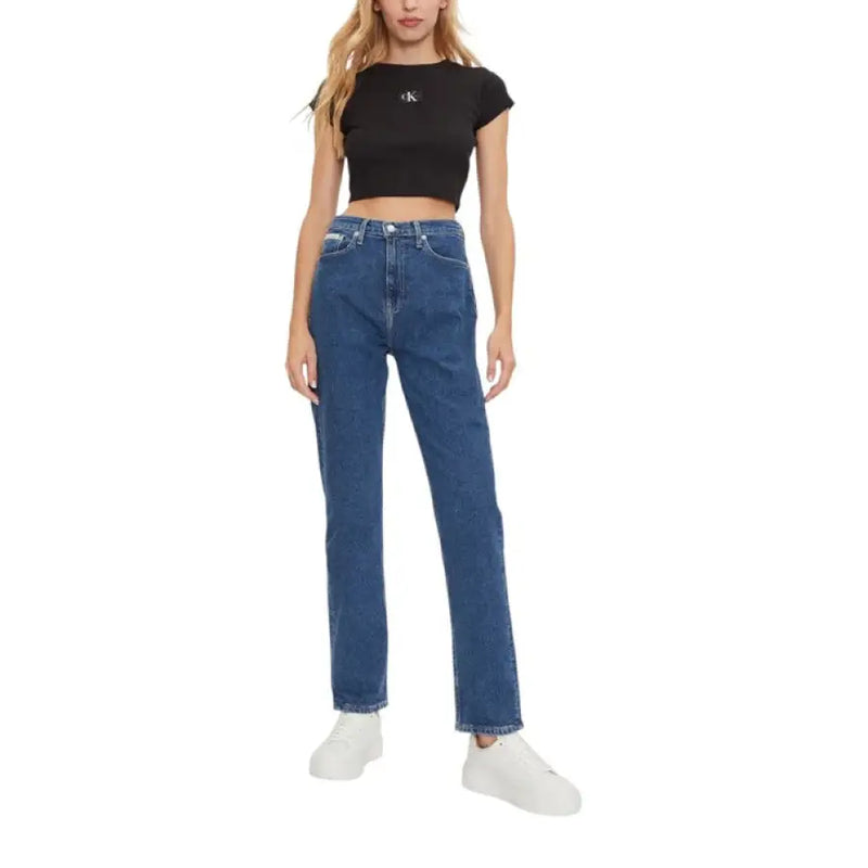 Woman wearing a black crop top and blue denim jeans for Women’s Black Crop Top and Blue Denim Jeans