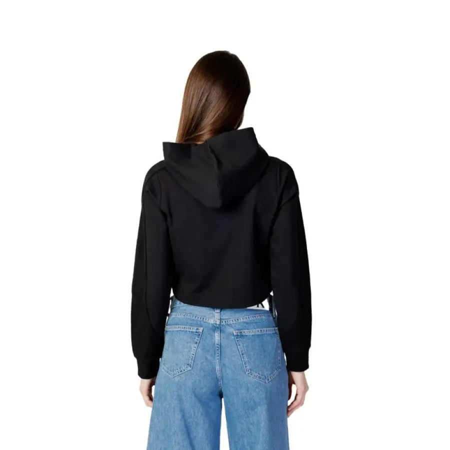 Woman in Calvin Klein black hoodie jacket and Klein jeans