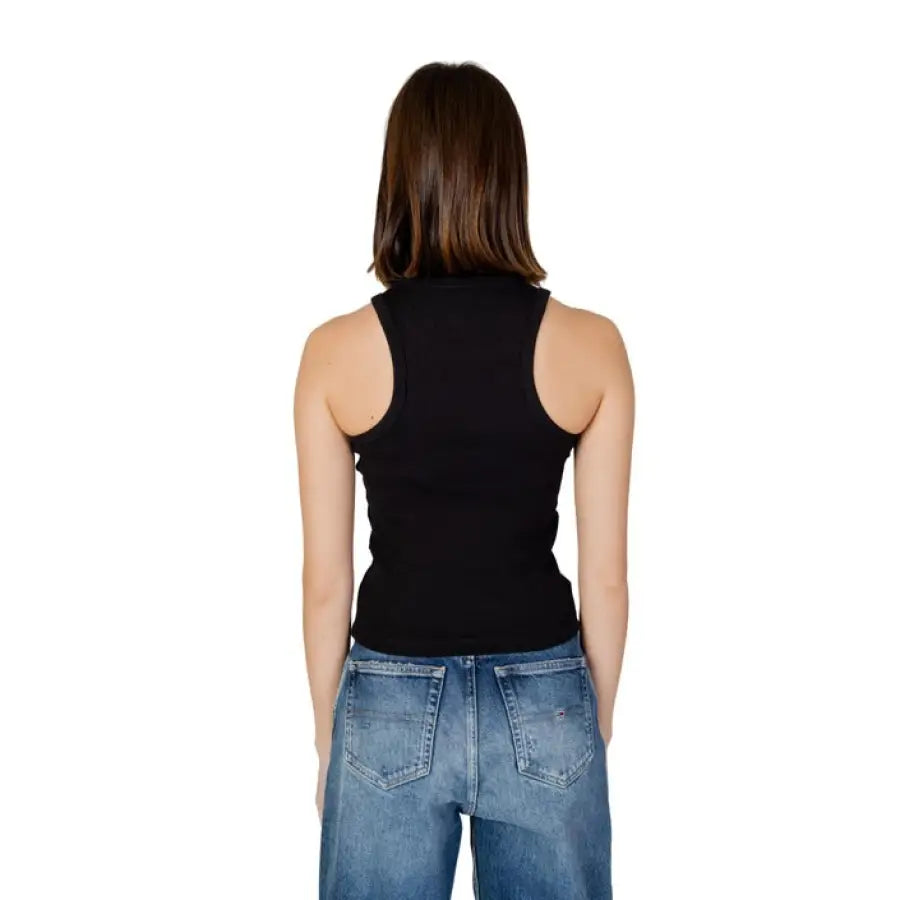 Woman modeling Tommy Hilfiger jeans and black top