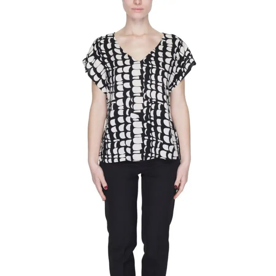 Woman in Jacqueline De Yong top, embodying urban city style with black pants and white shirt