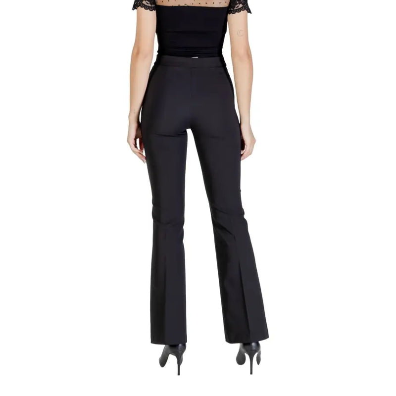 Woman wearing Rinascimento black fall winter trousers with pleats and a sheer dotted neckline top
