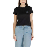 Woman wearing a black Tommy Hilfiger organic cotton tee with small logo and light blue drawstring pants