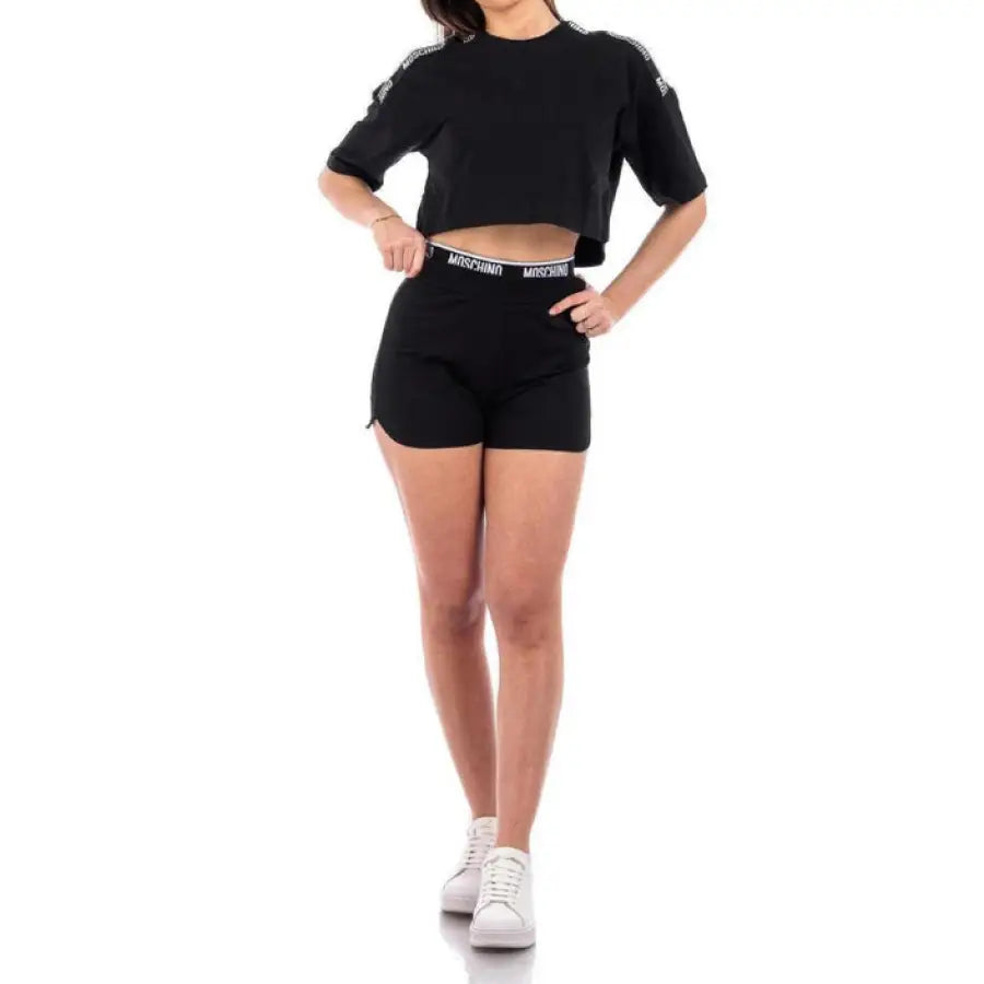 Woman in Moschino Underwear crop top and black shorts showcasing urban city fashion