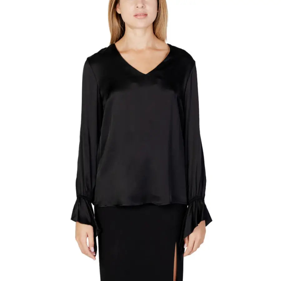 Woman in Sandro Ferrone black knitwear top and skirt