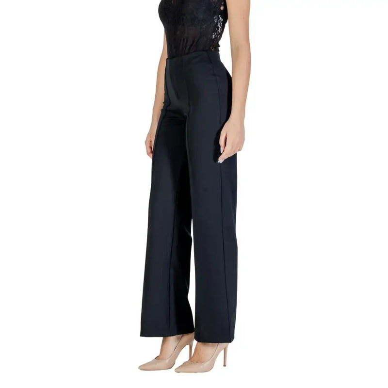 Woman in Guess Active Fall Winter Black Trousers, sleeveless sequined top, nude heels