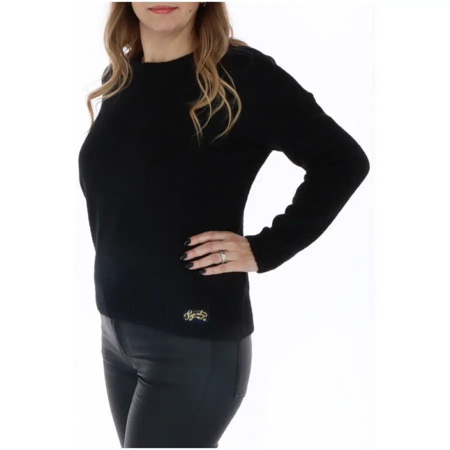 Superdry women knitwear model in black sweater and leather pants