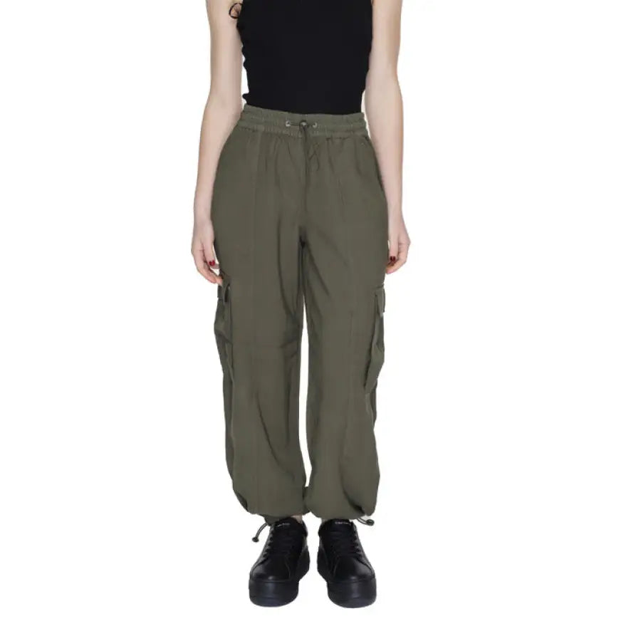 Woman in urban style clothing, black tank top and cargo pants by Only