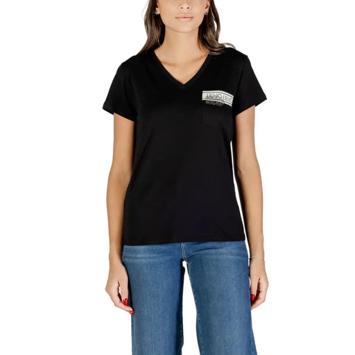 Frau trägt ein schwarzes Baumwollshirt mit V-Ausschnitt T-shirt mit Tasche und blauen Jeans
