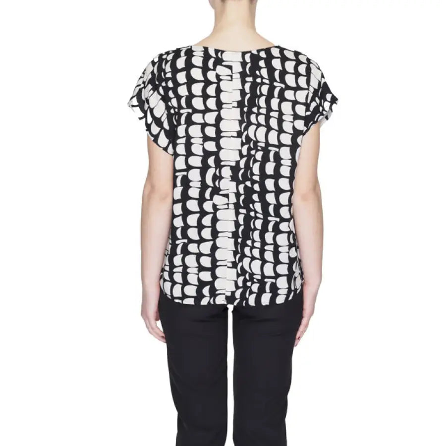 Woman in Jacqueline De Yong top showcasing urban city style on white surface