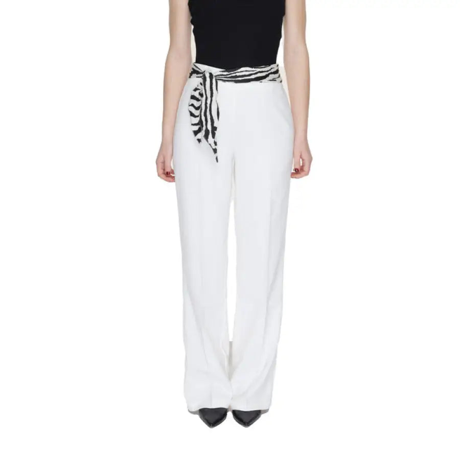 Woman in black top and white Only trousers showcasing urban city style fashion