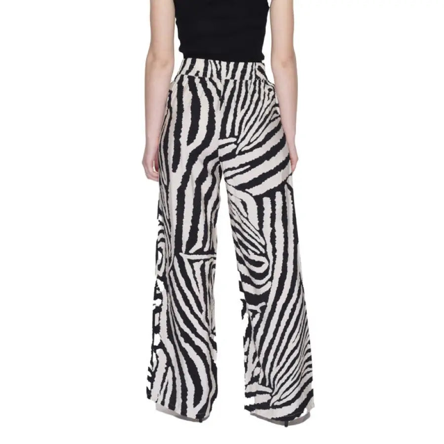 Woman sporting urban style clothing in black top and zebra print trousers