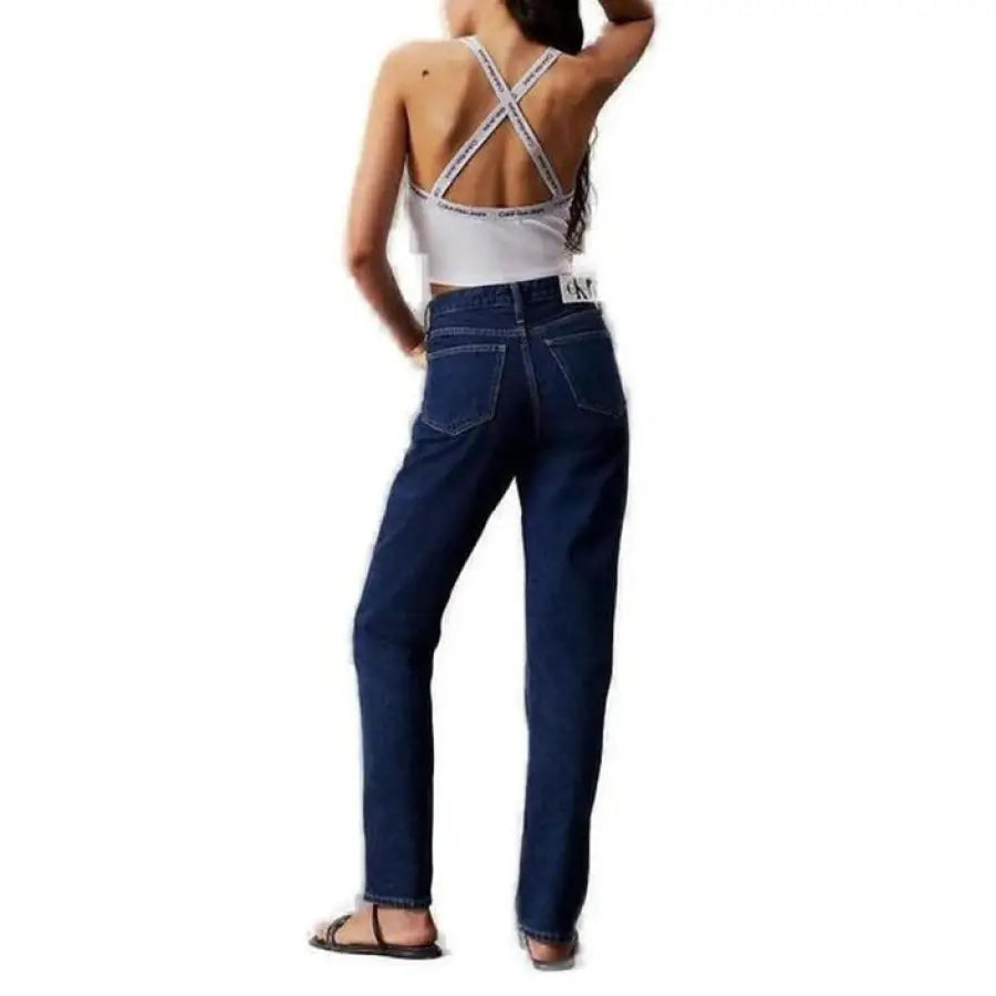 Woman posing in Calvin Klein jeans and undershirt tank top