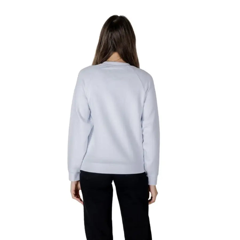 Woman wearing a light blue sweatshirt and black pants from Women’s Light Blue Sweatshirt and Black Pants collection