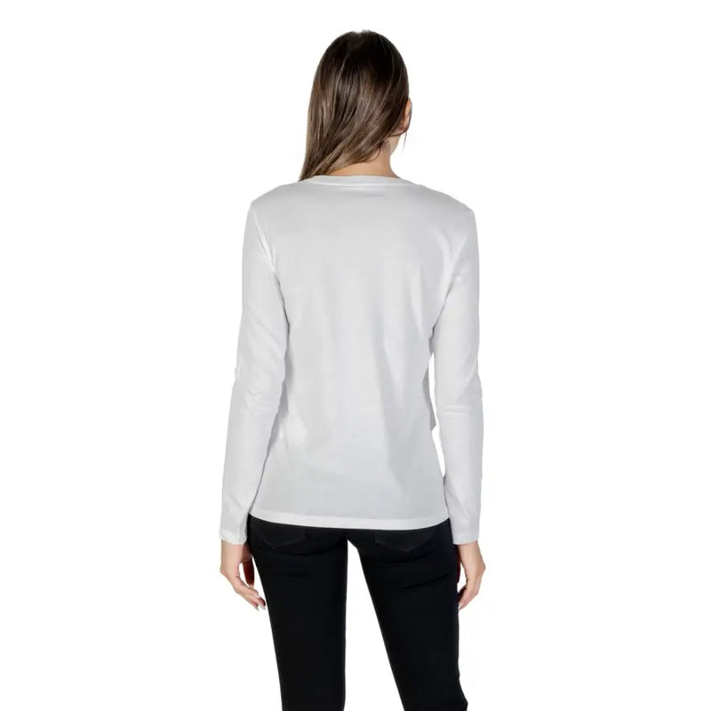 Woman modeling Armani Exchange white long sleeve T-shirt with rhinestone print and black pants