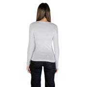 Woman in light grey long-sleeved shirt and dark jeans, back view, Guess Fall Winter T Shirt