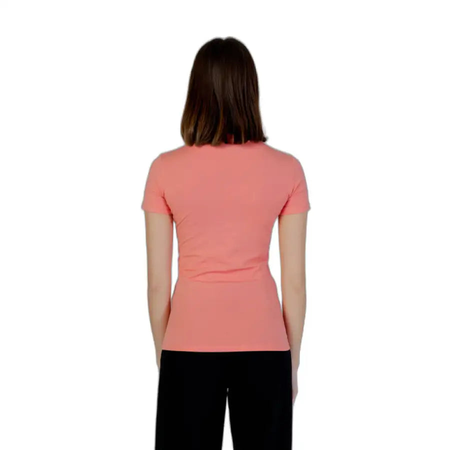Woman in Guess Women T-Shirt, pink shirt, standing back view