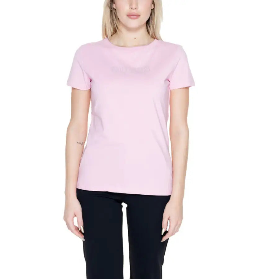 
                      
                        Woman in Guess Active pink t-shirt, showcasing urban city fashion
                      
                    