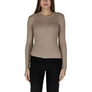 Woman in ribbed beige knit sweater and black pants showcasing Vila Clothes design