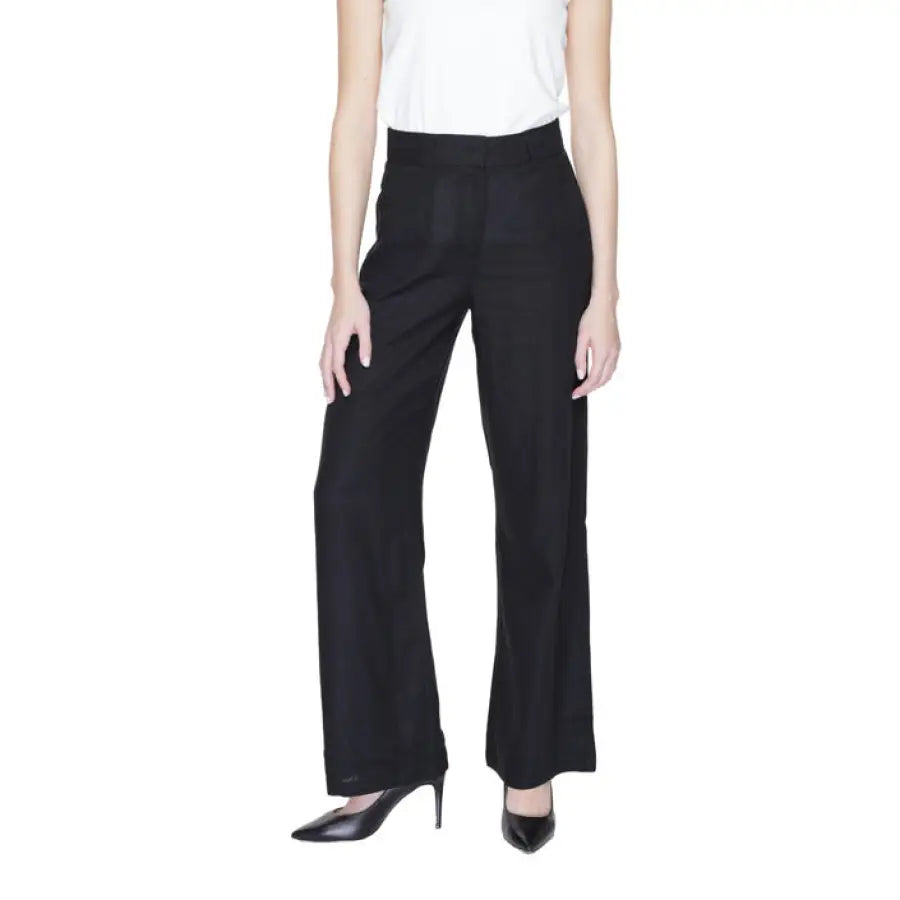 Vero Moda woman in urban style clothing - white top and black trousers