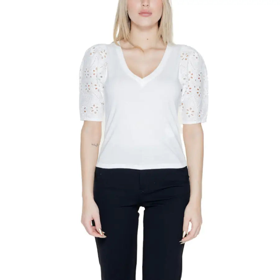 Woman in Morgan De Toi lace-sleeved white top showcasing urban city style