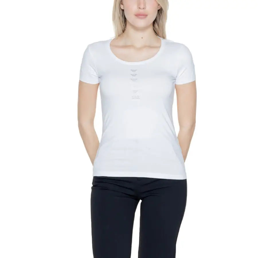 
                      
                        Woman in EA7 urban style clothing, white shirt and black pants, showcasing urban city fashion
                      
                    
