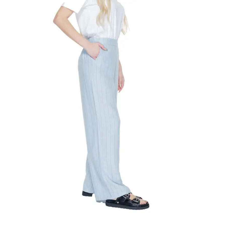 
                      
                        Woman in Vero Moda white shirt and blue pants for urban city fashion
                      
                    