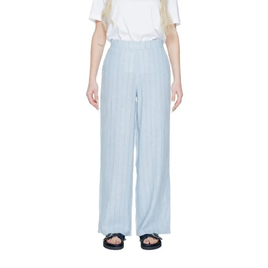 
                      
                        Vero Moda woman in urban style clothing, white shirt and blue pants
                      
                    