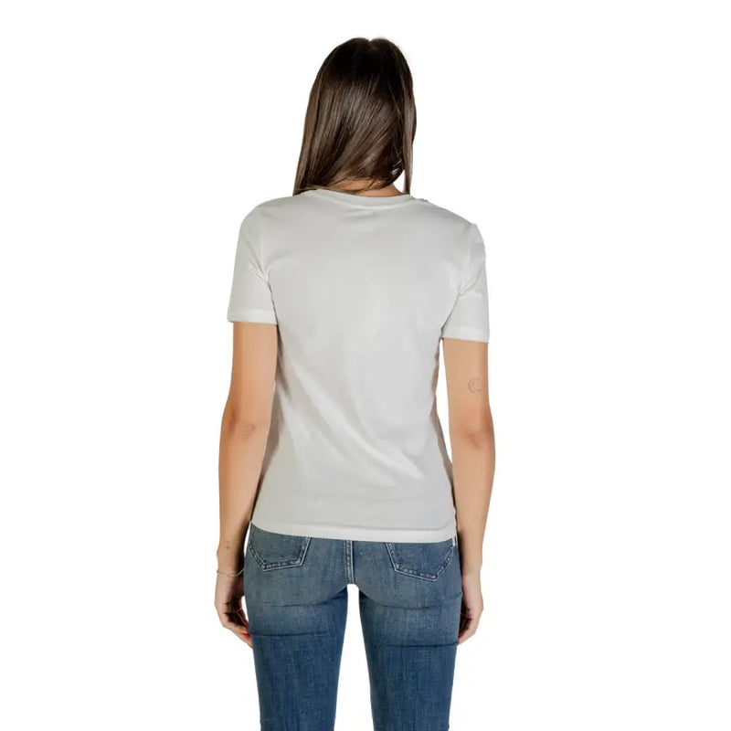 Woman in white short sleeve round neck cotton T shirt and blue jeans viewed from the back