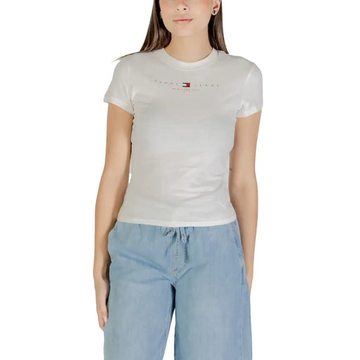 Woman wearing a white short-sleeved T-shirt and light blue wide-leg pants for Tommy Hilfiger Jeans
