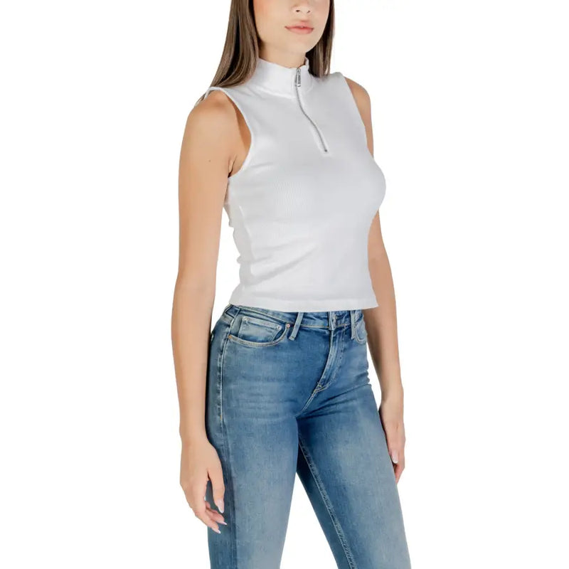 Woman wearing Calvin Klein Jeans white sleeveless zip turtleneck top with blue jeans