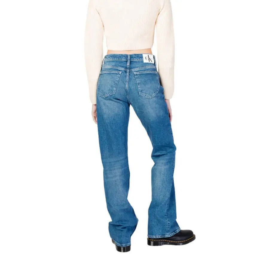 Woman in Calvin Klein Jeans white sweater and jeans