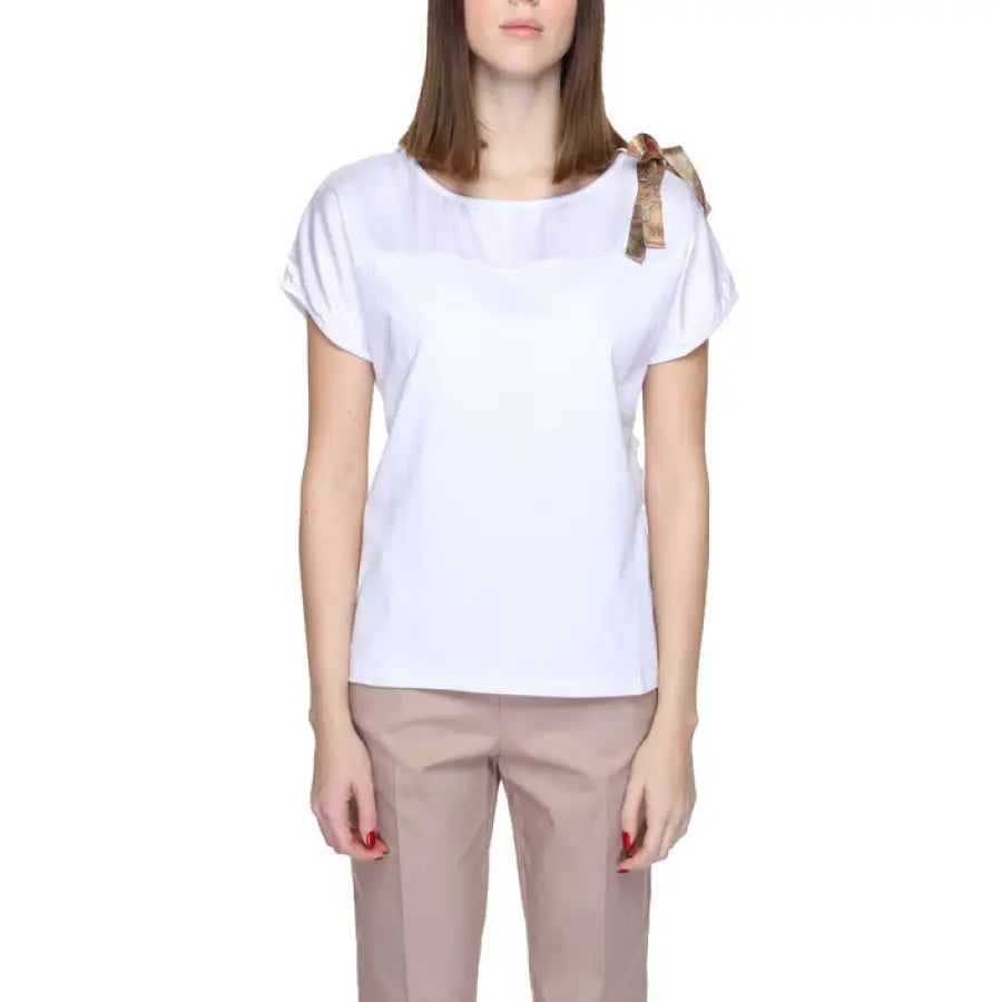 Woman in Alviero Martini Prima Classe white T-shirt and beige pants