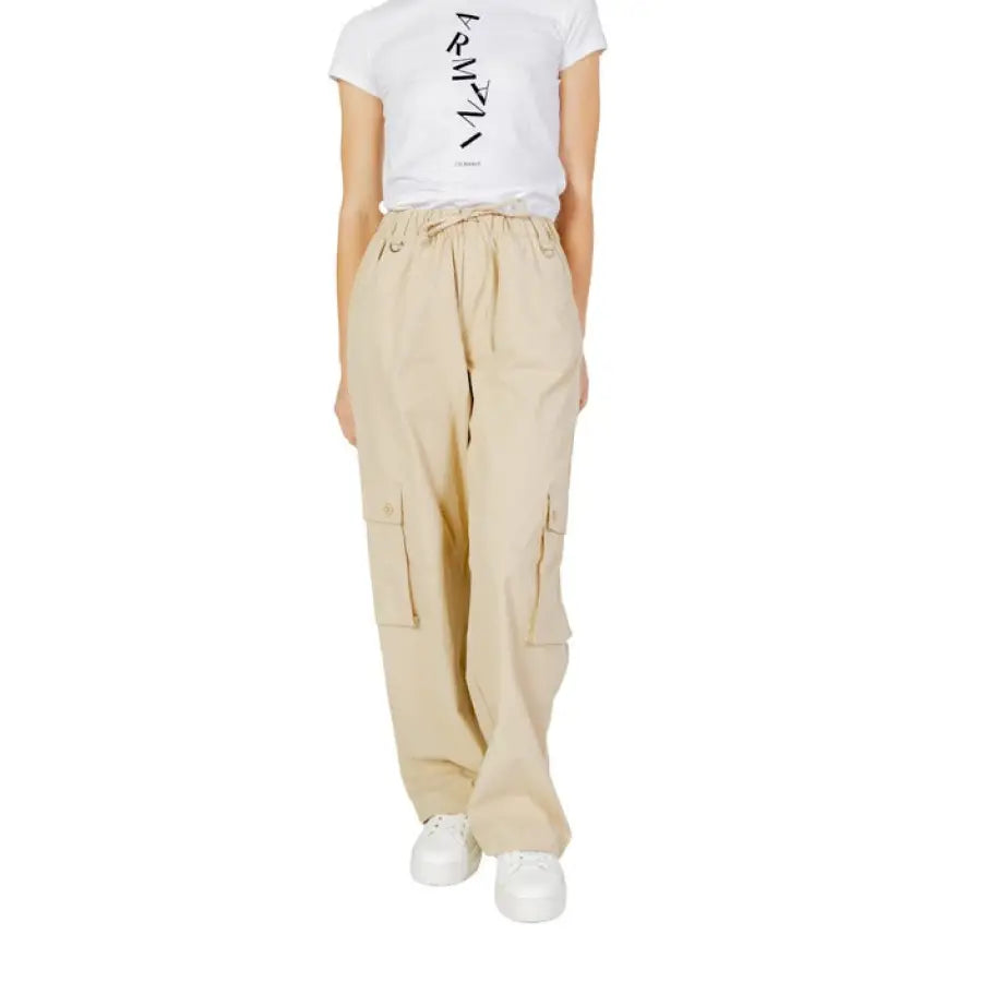 Woman in urban style clothing, white tee and beige women trousers, urban city fashion