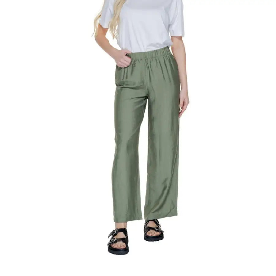 
                      
                        Woman in urban style clothing with white T-shirt and green Only trousers
                      
                    