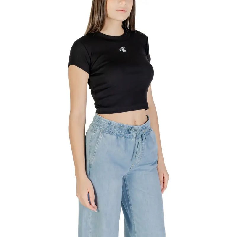 Woman wearing black Calvin Klein crop top and light blue wide-leg jeans
