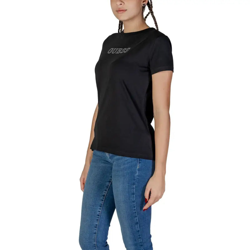 Woman wearing black crew-neck T-shirt with short sleeves and blue jeans for Guess Active Spring Summer collection