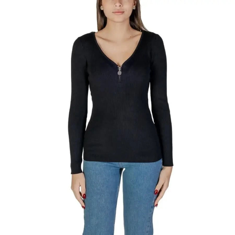 Woman wearing a black long-sleeved ribbed top from Morgan De Toi white knit sweater