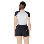 Woman wearing a black and white athletic crop top with black shorts for activewear