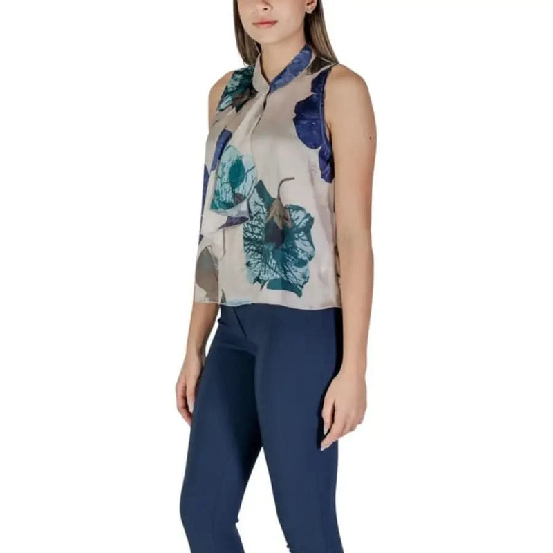 Woman wearing Rinascimento Floral Sleeveless Green Blouse with blue pants