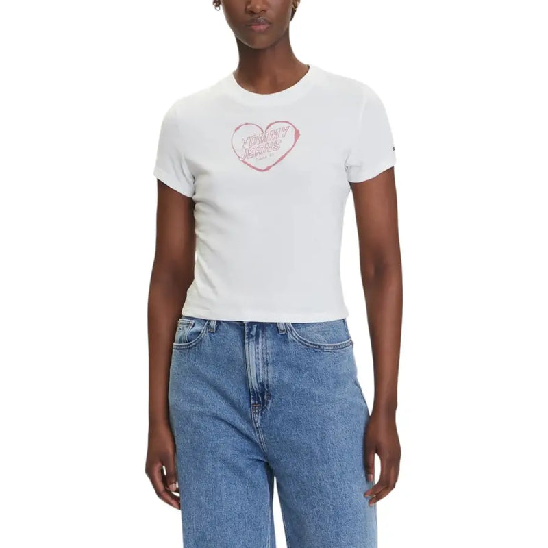 Woman wearing Tommy Hilfiger white organic cotton T shirt with pink heart graphic and jeans