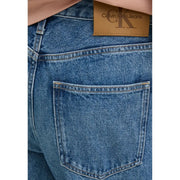 Blue denim women’s casual jeans shown from the back featuring a brown leather calvin klein brand patch on waistband