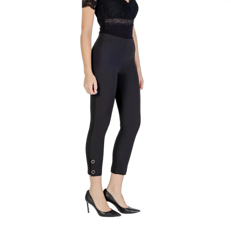 Women’s black high-waisted skinny cropped leggings with silver ring details and black heels