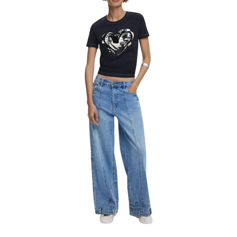 Women wearing Desigual black short-sleeve crop top with white heart graphic and light-wash wide-leg jeans
