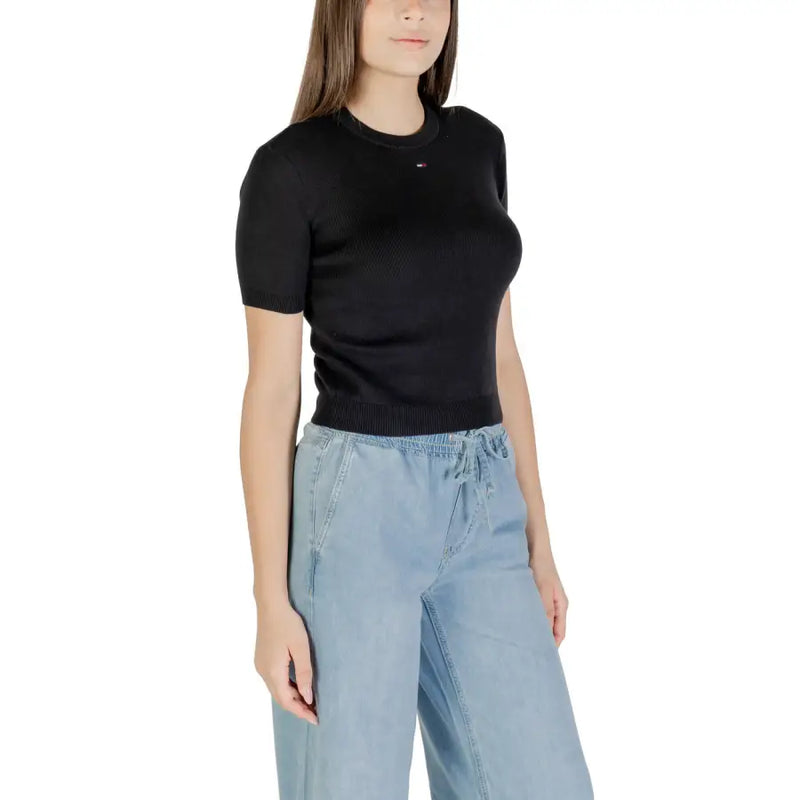 Women wearing black organic cotton round neck T shirt and light-wash denim wide-leg pants