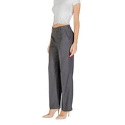 Women’s dark grey wide-leg trousers with white ruffled crop top and nude high heels