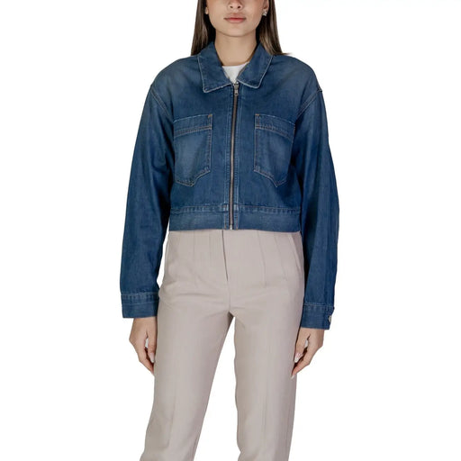 Women’s blue denim zip up blazer with front zipper and two chest pockets made of durable denim material