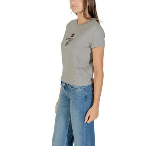 Women wearing a gray short-sleeved T-shirt with blue wide-leg jeans, showcasing Tommy Hilfiger style