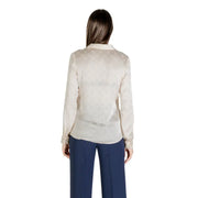 Women’s beige long sleeve button-up shirt with round neck paired with dark blue wide-leg pants